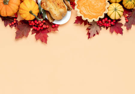 Thanksgiving Day concept, view from above on autumn natural foliage decor and traditional foods, festive dinner invitation background with blank space for a textの写真素材