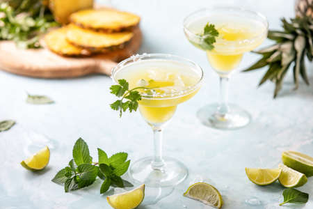 Pineapple coriander infused margarita in glasses with ingredients, front viewの写真素材