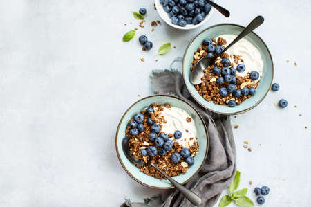 Granola and blueberry breakfast with plain yogurt, top down view, space for a textの写真素材