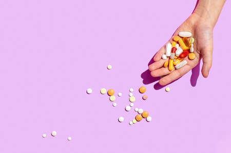 Various pills lying in a hand, overhead view, copy space for a text