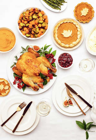 Thanksgiving dinner table setting, overhead view of placed dinnerware with traditional festive Thanksgiving foodの写真素材