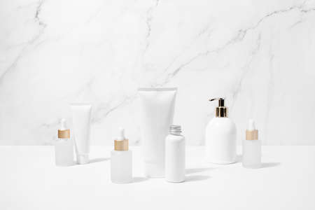 Face or body care cosmetic products concept, bottles of lotion and serum standing on white surfaceの写真素材