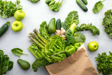 Green vegetables in a paper shopping bag, top-down view, sustainable living conceptの写真素材