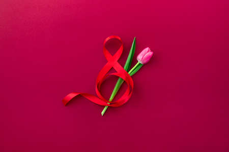 The Eighth of March world women's Day celebration greeting card or banner template, top-down view of spring flowers bouquet decorated with red ribbon styled like figure "8"の写真素材