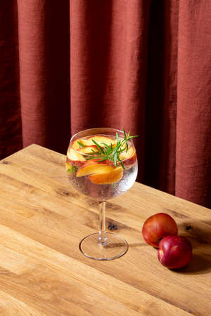 Peach and rosemary Gin Tonic summer cocktail in a glass, summer drink recipe conceptの写真素材