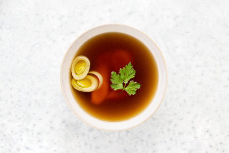 Basic bone broth in a bowl, overhead viewの写真素材