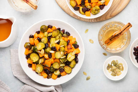 Roasted brussels sprouts salad with maple butternut squash, pumpkin seeds, and cranberries, top down viewの写真素材