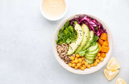 Vegan Buddha bowl with roasted chickpeas and tahini sauce, top down view, copy space for a textの写真素材