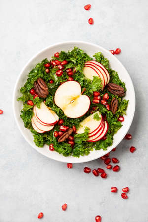 Kale apple and pomegranate salad vegan recipe, top-down view of ready-to-eat meal served in a bowlの写真素材