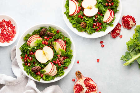 Kale apple and pomegranate salad vegan recipe, top-down view of ready-to-eat meal served in a bowlの写真素材