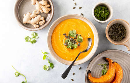Ginger and pumpkin vegetarian soup with ingredients, top down viewの写真素材