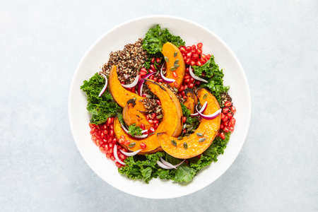 Roasted squash and kale quinoa salad in a white bowl, overhead viewの写真素材