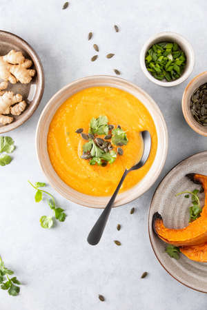 Ginger and pumpkin vegetarian soup with ingredients, top down viewの写真素材