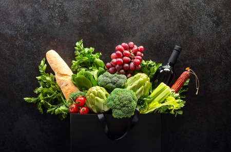 Premium food store concept or background, dark shopping bag with  fresh produce, wine and breadの写真素材