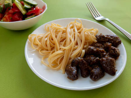 spaghetti with chicken hearts and saladの写真素材