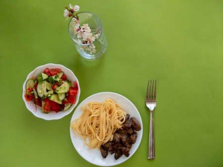spaghetti with chicken hearts and saladの写真素材
