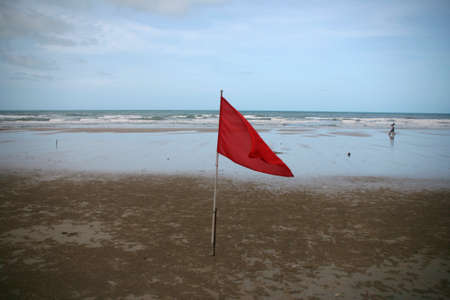 red flag on the beach horizontal danger by the wavesの写真素材