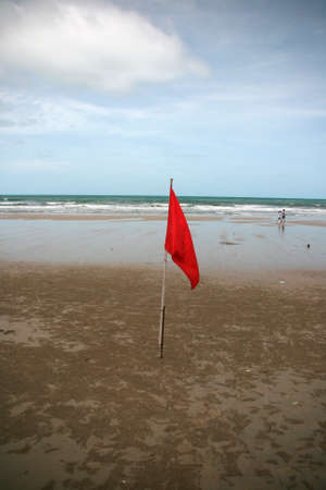 red flag on the beach vertical danger by the wavesの写真素材