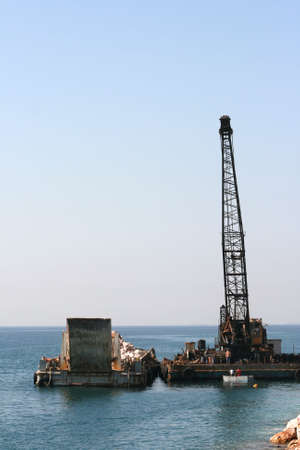 floating crane unloading flat barge full of stonesの写真素材