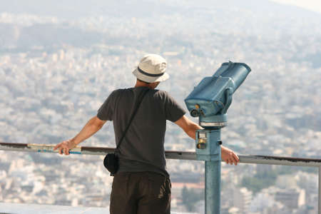 man tourist watching the view of athens from the top of lycabetusの写真素材