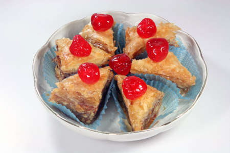 baklava pieces with cherries in a plate の写真素材
