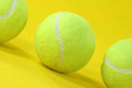 closeup three yellow tennis balls in yellow background sports conceptsの写真素材