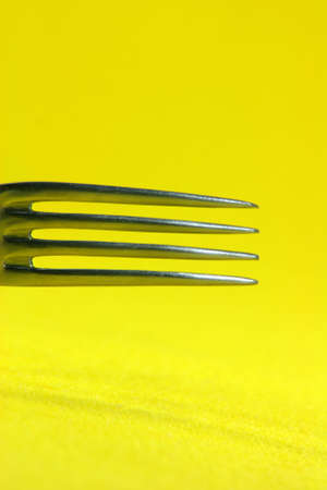 food and reasturants concepts fork detail in yellow backgroundの写真素材