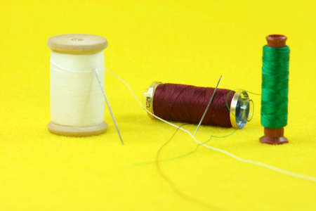 string rolls and needles in yellow background sewing handcrafted concepts
