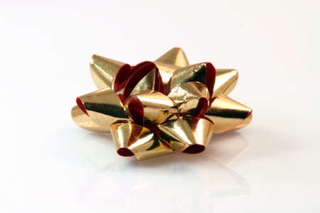 gold gift bow on white background with reflection