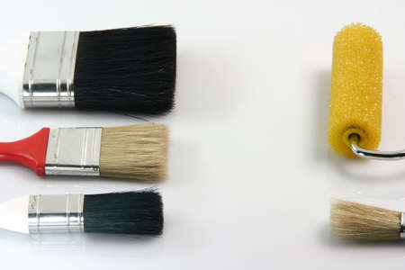 detail from four paint brushes and paint roll on white background hardware tools with copy spaceの写真素材