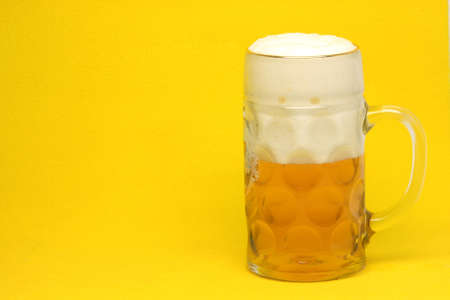 classic bavarian beer mug in yellow background with copy spaceの写真素材
