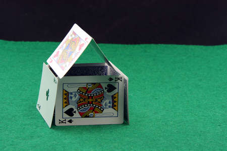 house made of playing cards on green felt with copy space blackのeditorial素材
