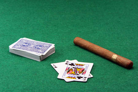 gambling ace with king stack of cards and a large cuban cigar on green feltのeditorial素材