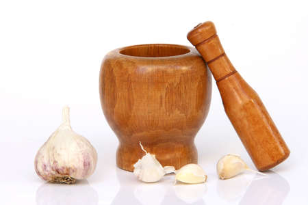 wooden mortar and pestle with garlic isolated with reflectionの写真素材
