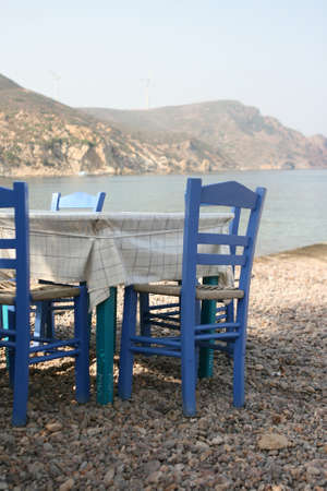 blue chairs by the sea at traditional greek taverna patmos island dodecanese greeceの写真素材