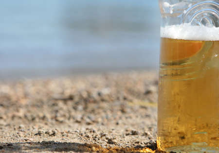 closeup detail  of beer botle on the beach defocus background