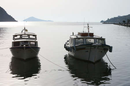 two wooden boats moored at harbor of skala patmos greeceの写真素材