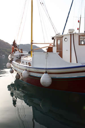 detail from traditional wooden sail boat reflected on water patmos greeceの写真素材