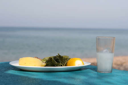 sea sky and food boiled mixed vegetables salad with glass of ouzo greeceの写真素材
