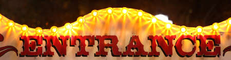 retro entrance sing with lights at night at amusement parkの写真素材