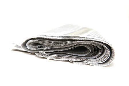 closeup detail from folded newspaper isolated on white backgroundの写真素材