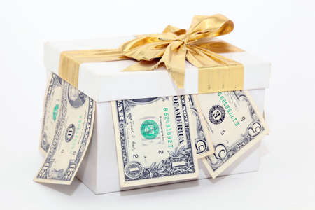 expensive white gift box with gold ribbon and bow and dollarsの写真素材