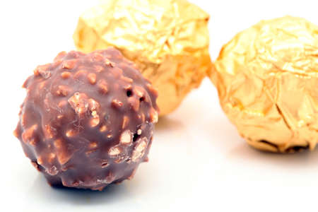 closeup chocolate sphere with nuts with gold wraped defocus backgroundの写真素材