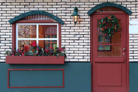 window and door decorated for xmas with lights artificial houseの写真素材