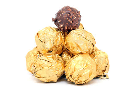 gold wraped chocolate balls pyramid isolated on white backgroundの写真素材