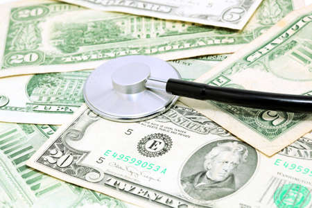 expensive health treatment stethoscope on dollar backgroundの写真素材