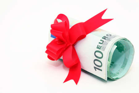 hundred euro banknotes rolled with gift ribbon isolatedの写真素材