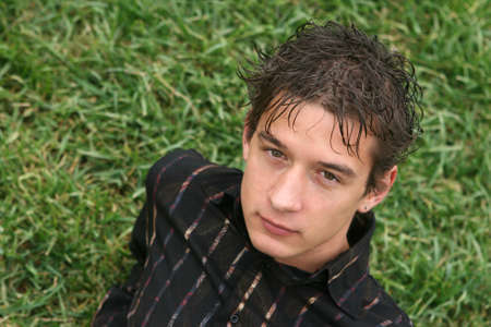 young man seating on grass looking frontの写真素材