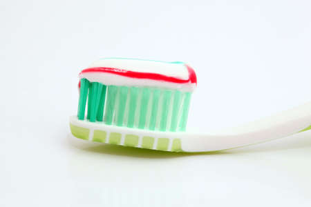 toothpaste on green toothbrush closeup on white backgroundの写真素材
