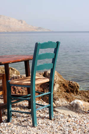 old green chair by the sea detail from greek taverna leros island greeceの写真素材